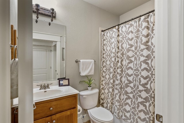 bathroom with walk in shower, a textured ceiling, vanity, and toilet