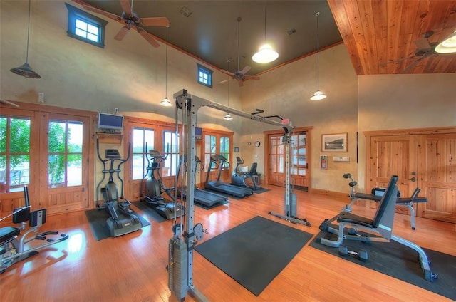 workout area with hardwood / wood-style floors, ceiling fan, french doors, and high vaulted ceiling