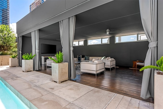 view of patio featuring a wooden deck, outdoor lounge area, and ceiling fan