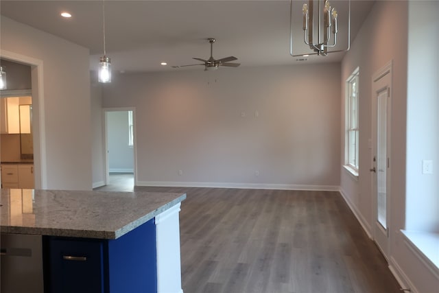 kitchen featuring blue cabinets, ceiling fan, hanging light fixtures, dark wood-type flooring, and dark stone counters