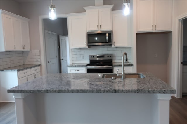 kitchen featuring pendant lighting, dark wood-type flooring, sink, white cabinets, and stainless steel appliances