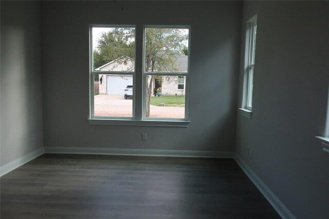 unfurnished room with dark hardwood / wood-style floors and a wealth of natural light