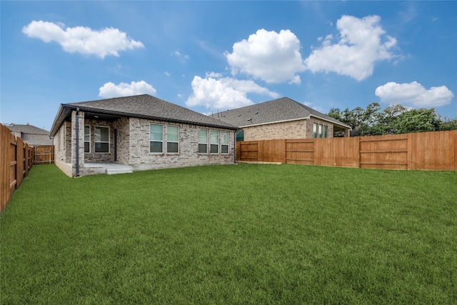 rear view of house with a lawn and a patio area