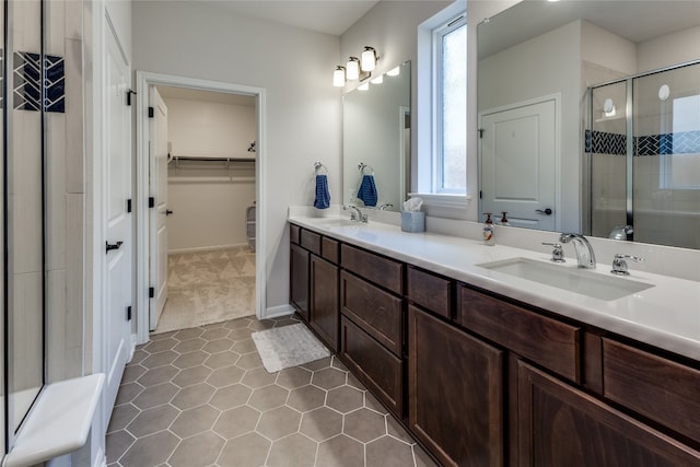 bathroom featuring a healthy amount of sunlight, vanity, tile patterned floors, and a shower with door