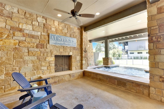 interior space with ceiling fan, concrete flooring, and an outdoor stone fireplace