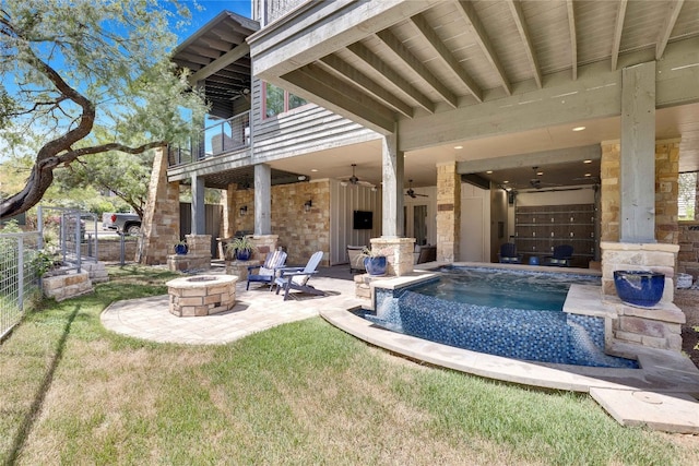 view of pool with a lawn, ceiling fan, a patio area, and an outdoor fire pit