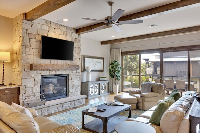 living room with beam ceiling, ceiling fan, hardwood / wood-style flooring, and a fireplace