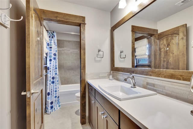 full bathroom with vanity, tile patterned flooring, tasteful backsplash, shower / tub combo, and toilet