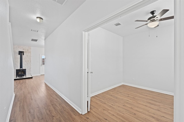 hall with a textured ceiling and light hardwood / wood-style flooring