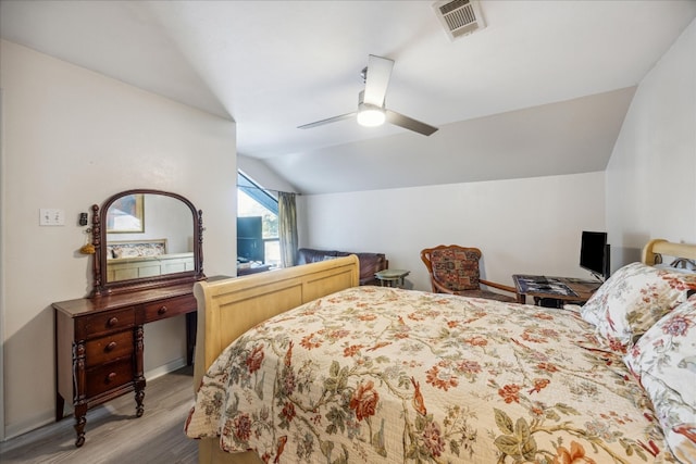 bedroom with ceiling fan, lofted ceiling, and light wood-type flooring