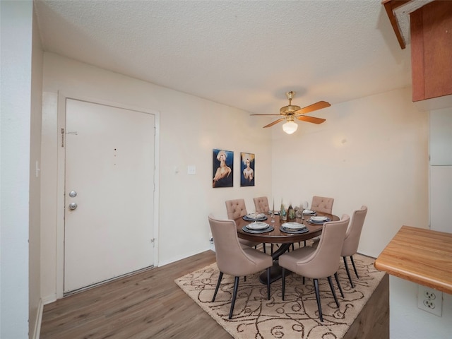 dining space with a textured ceiling, hardwood / wood-style flooring, and ceiling fan