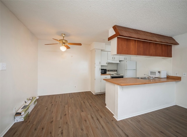 kitchen featuring white cabinets, dark wood-type flooring, kitchen peninsula, and white appliances