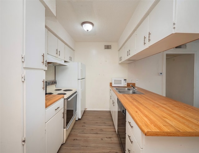 kitchen with white cabinets, white appliances, light wood-type flooring, a textured ceiling, and sink