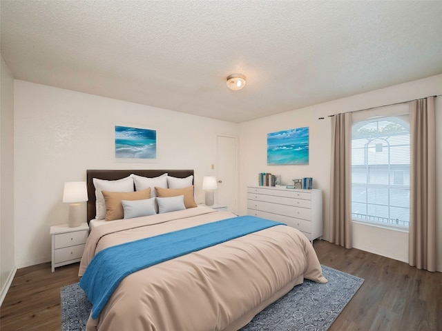 bedroom with a textured ceiling and dark hardwood / wood-style floors