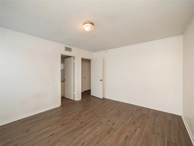 interior space featuring a textured ceiling and dark wood-type flooring