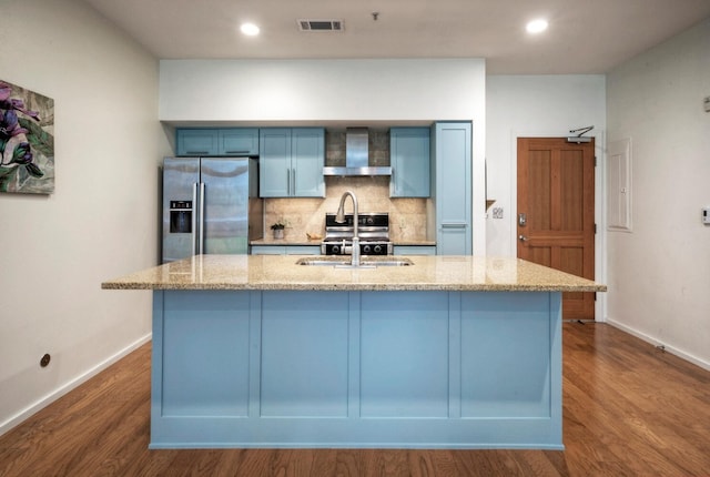 kitchen with wall chimney exhaust hood, appliances with stainless steel finishes, dark wood-type flooring, and sink