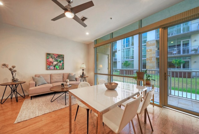 dining room with ceiling fan, floor to ceiling windows, and hardwood / wood-style floors