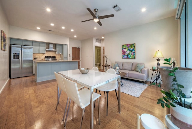 dining room featuring ceiling fan, light hardwood / wood-style flooring, and sink