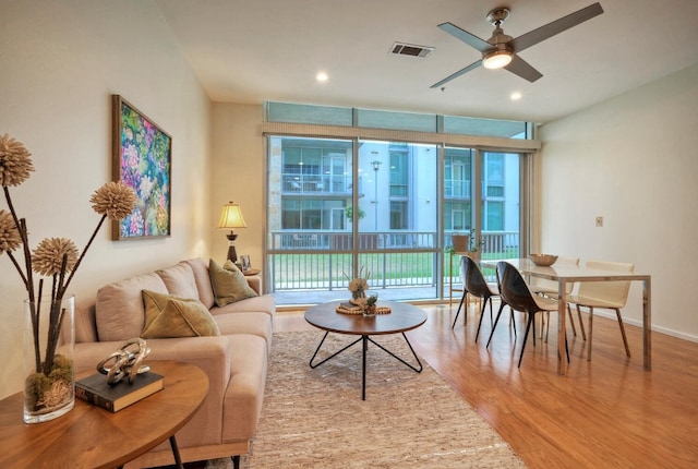 living room with ceiling fan, hardwood / wood-style floors, and expansive windows