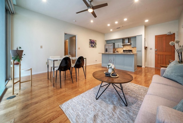 living room with ceiling fan and light hardwood / wood-style floors