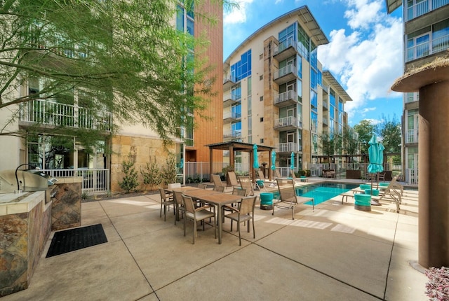 exterior space with a balcony and a community pool