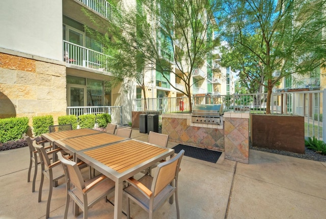 view of patio featuring grilling area, a balcony, and exterior kitchen