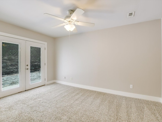 empty room featuring ceiling fan, french doors, and carpet floors