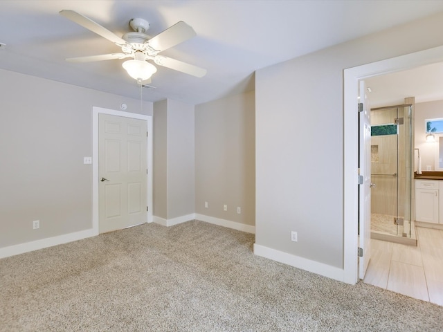 unfurnished room featuring ceiling fan and light carpet