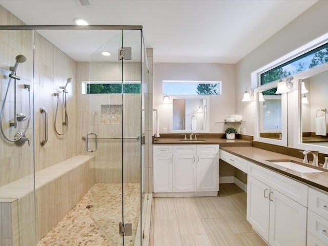 bathroom with vanity and a shower with door