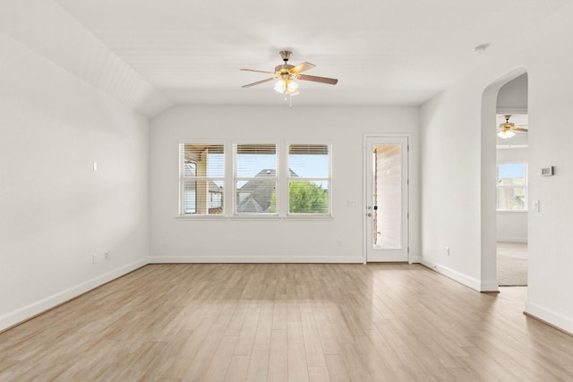 spare room with ceiling fan, vaulted ceiling, and light wood-type flooring