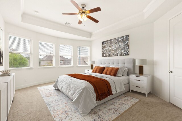 carpeted bedroom featuring a raised ceiling, ceiling fan, and ornamental molding