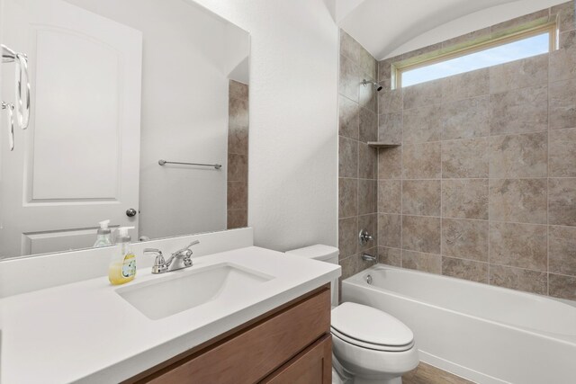 full bathroom with vanity, tiled shower / bath combo, and toilet