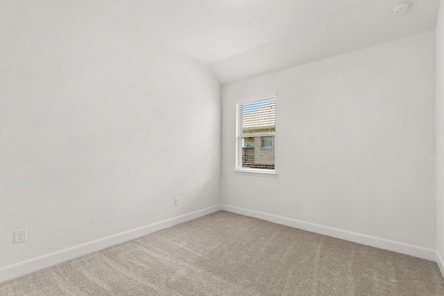 empty room with carpet floors and vaulted ceiling