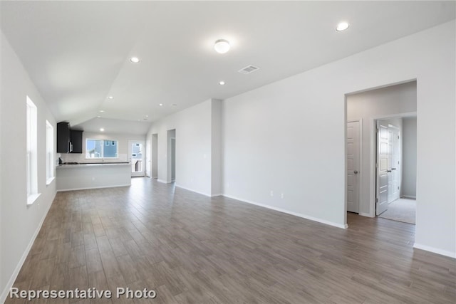 unfurnished living room with lofted ceiling and dark wood-type flooring