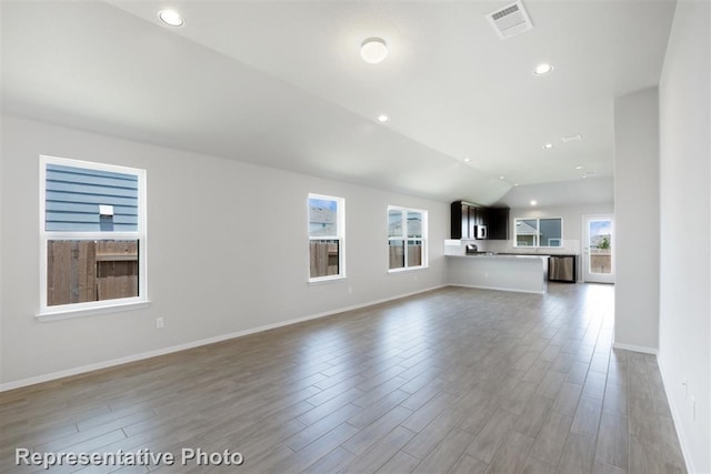 unfurnished living room featuring wood-type flooring and lofted ceiling