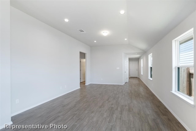 unfurnished living room featuring lofted ceiling and dark hardwood / wood-style floors