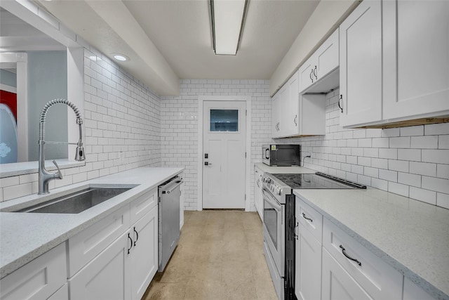 kitchen with white cabinets, sink, backsplash, stainless steel appliances, and light stone countertops