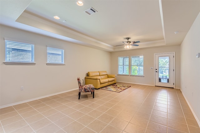 unfurnished room featuring a raised ceiling, light tile patterned floors, and ceiling fan