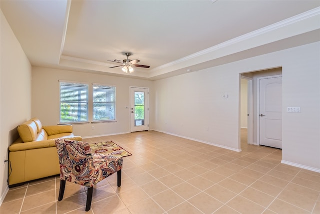 interior space featuring ornamental molding, light tile patterned floors, a tray ceiling, and ceiling fan