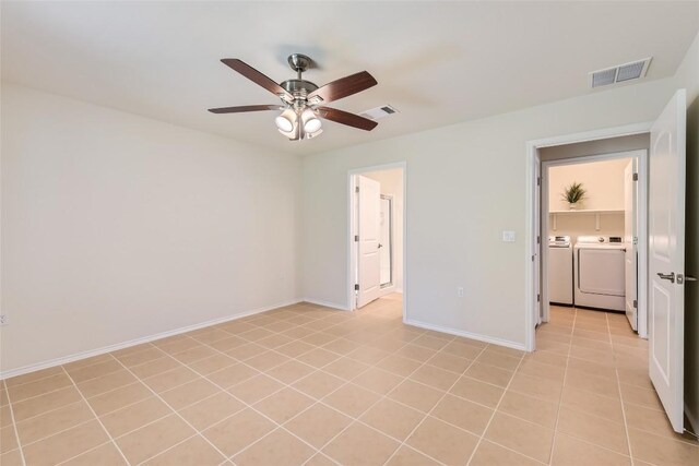 unfurnished bedroom featuring ceiling fan, light tile patterned floors, and washing machine and dryer