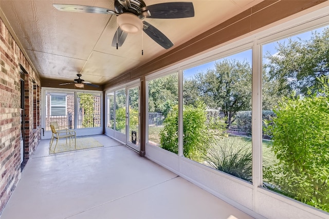 unfurnished sunroom featuring ceiling fan