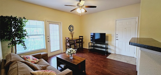 living room with ceiling fan and dark wood-type flooring