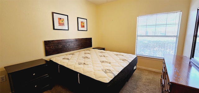 bedroom featuring dark colored carpet and multiple windows