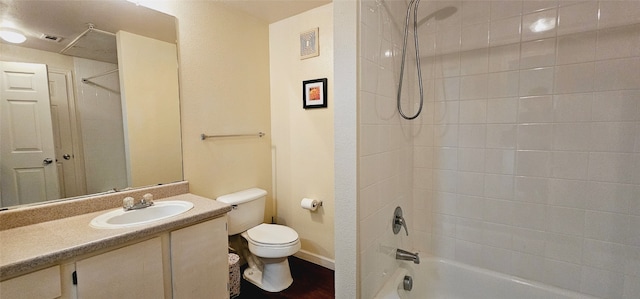 full bathroom with tiled shower / bath, vanity, and toilet