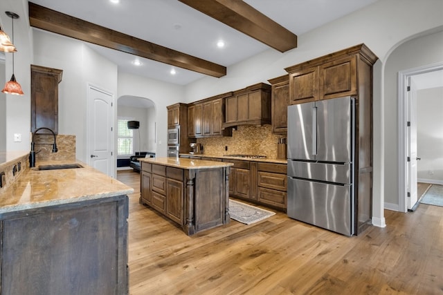 kitchen with beamed ceiling, sink, backsplash, appliances with stainless steel finishes, and light wood-type flooring