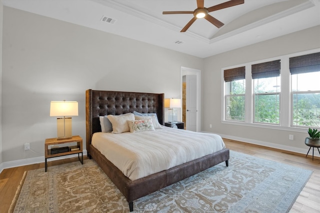 bedroom featuring ceiling fan, ornamental molding, lofted ceiling, and hardwood / wood-style floors