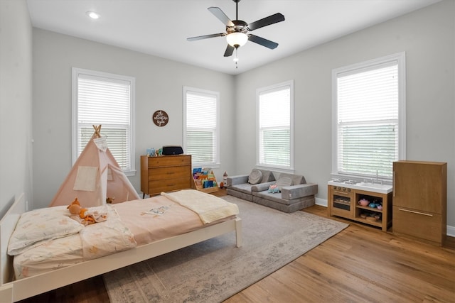 living area featuring light wood-type flooring and ceiling fan