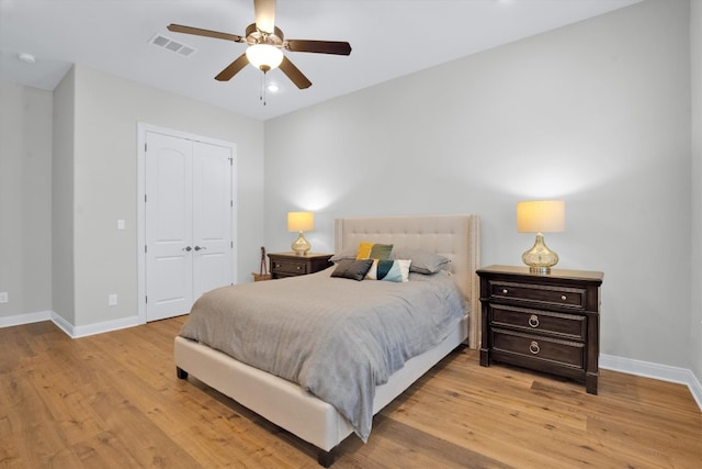 bedroom featuring light hardwood / wood-style floors, ceiling fan, and a closet