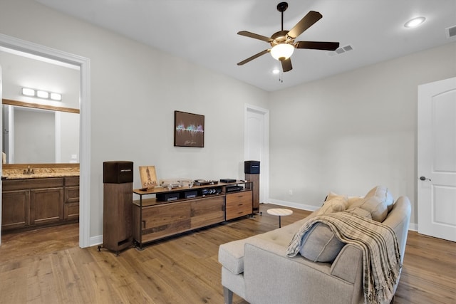 sitting room featuring ceiling fan, light wood-type flooring, and sink