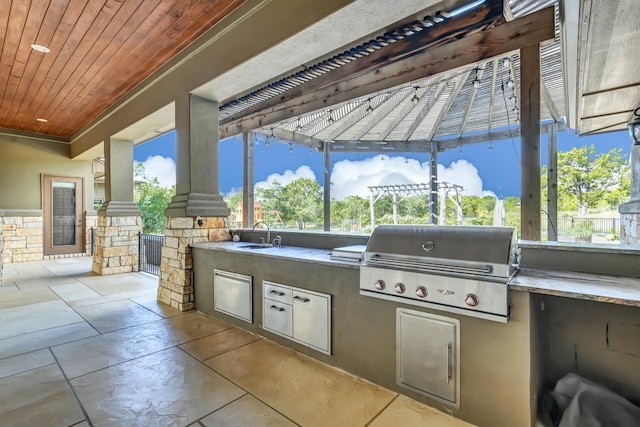 view of patio featuring area for grilling, sink, and a pergola